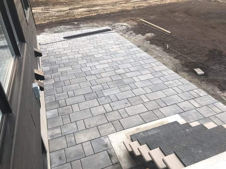 Un patio avec des escaliers qui y mènent est en cours de construction devant une maison.