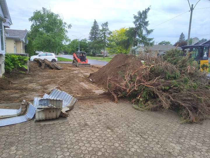 Un tas de branches est posé sur le sol devant une maison.