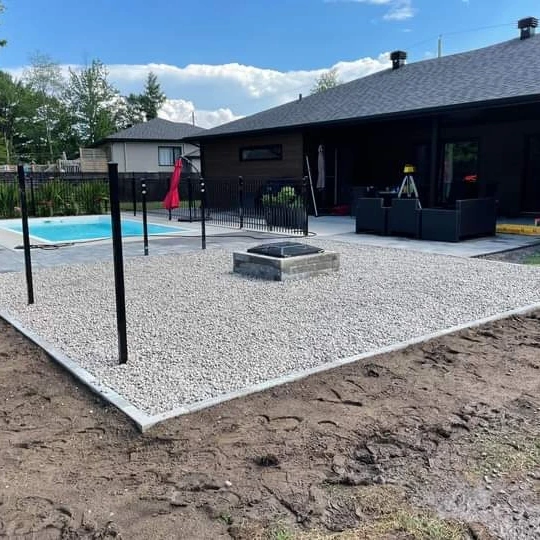 Un patio avec un foyer et une piscine devant une maison.