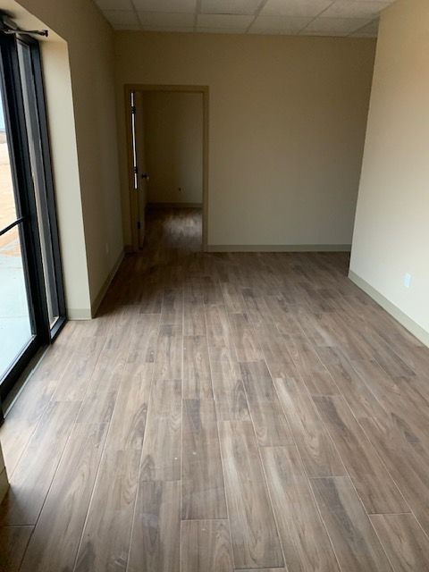 An empty room with a wooden floor and a window.