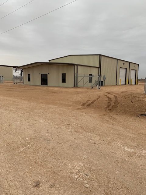A large building in the middle of a dirt field