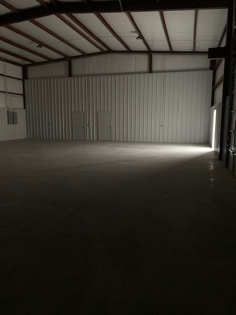 An empty warehouse with a light coming through the door