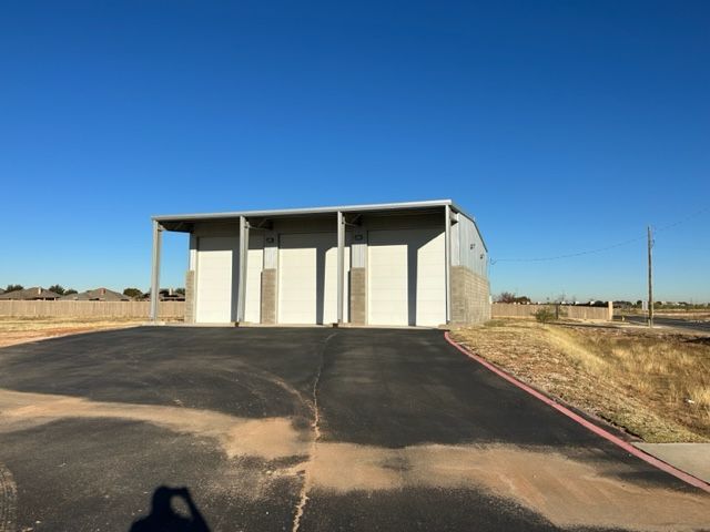 A shadow of a person is cast on the ground in front of a building