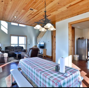 A table with a plaid tablecloth is in a living room