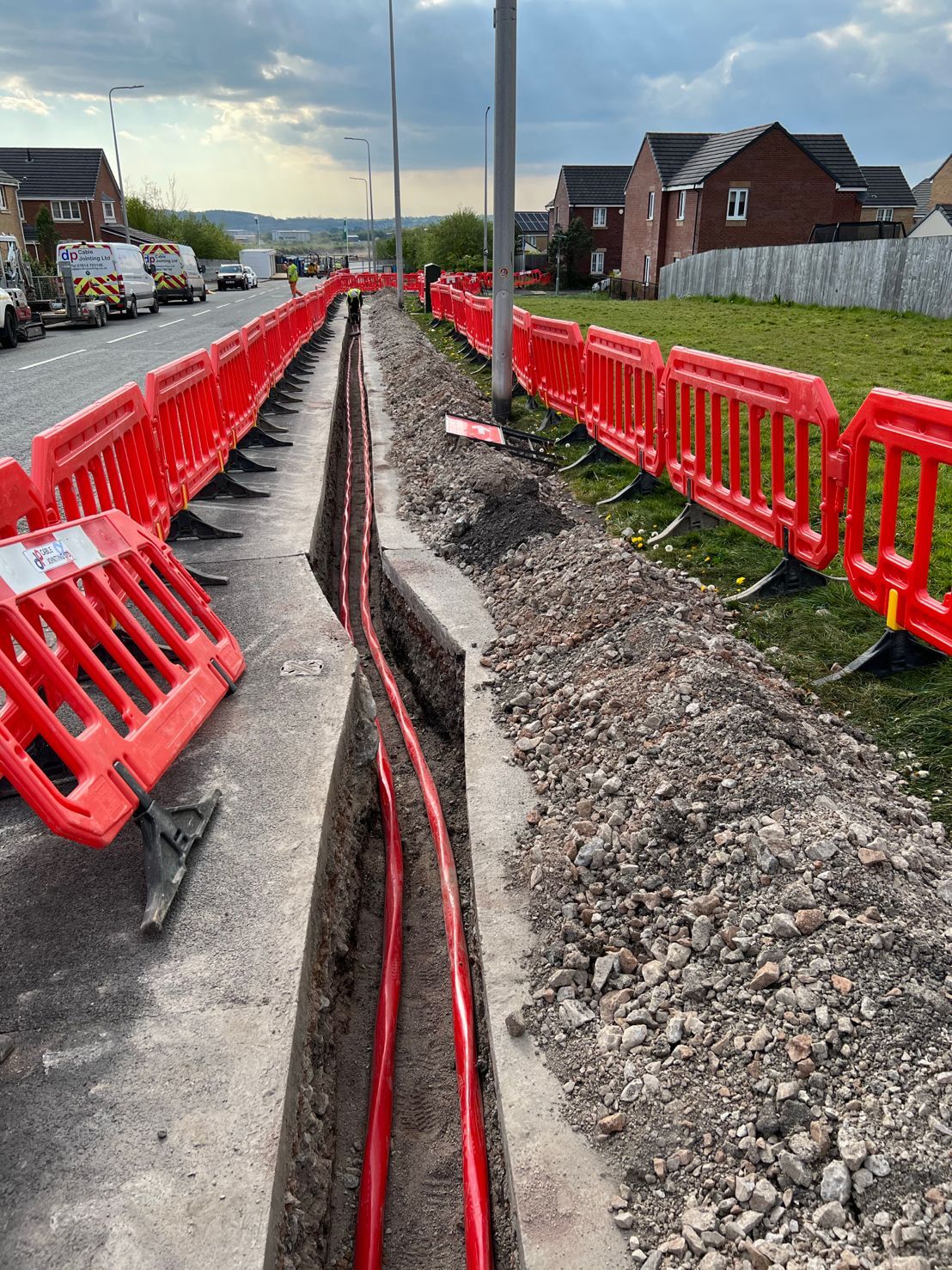 DP Cable Jointing | A row of red barriers are sitting on the side of a road.