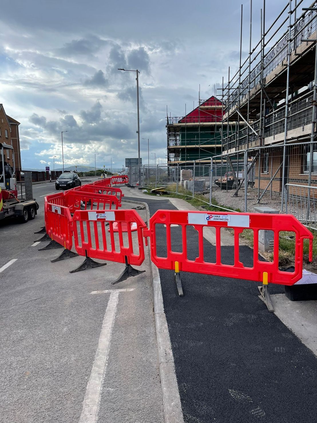 DP Cable Jointing | A row of red and white barriers on the side of a road.