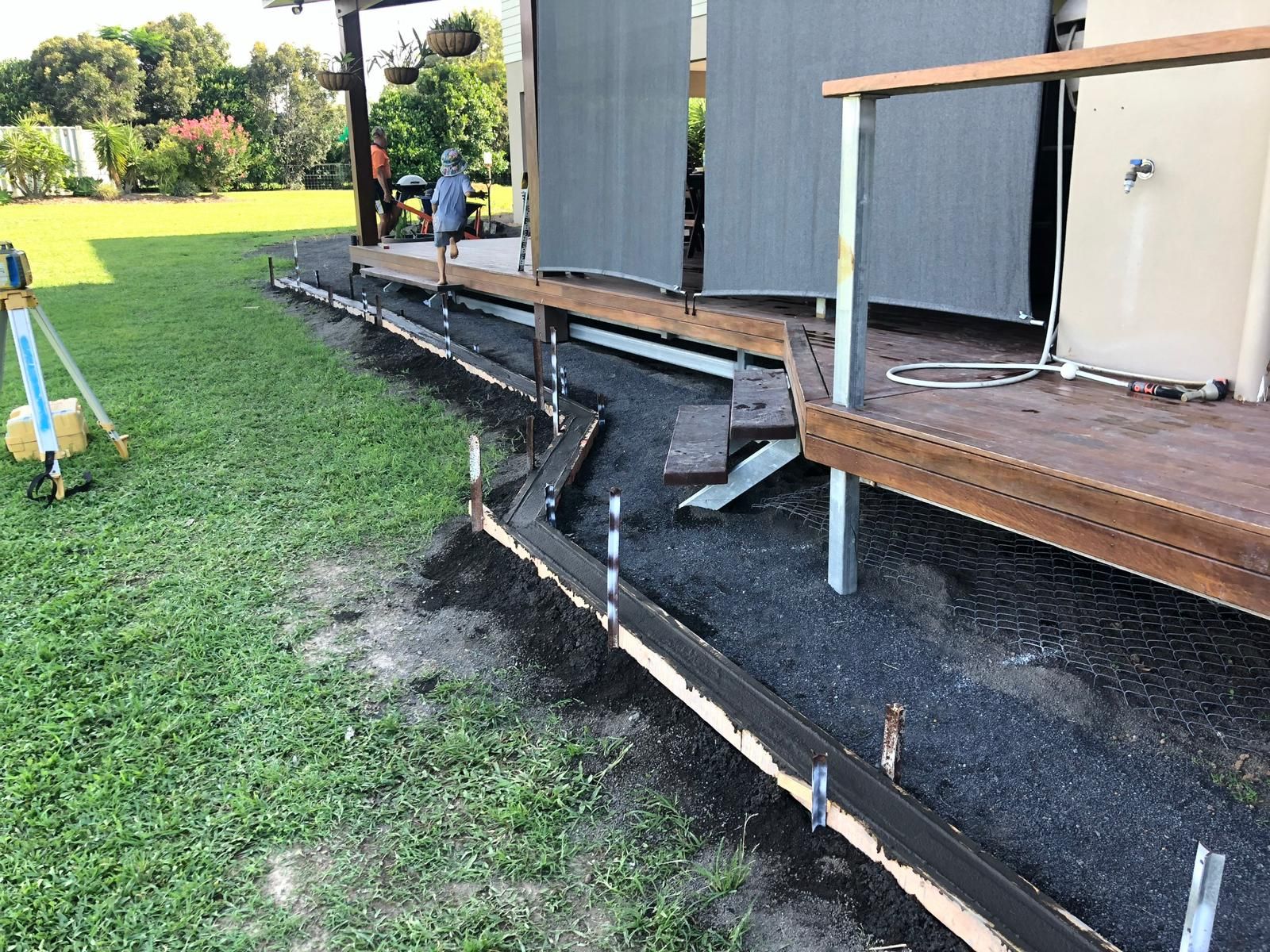Construction Site With a Concrete Border Being Poured Alongside a Wooden Deck — Ericson Constructions in Mareeba, QLD