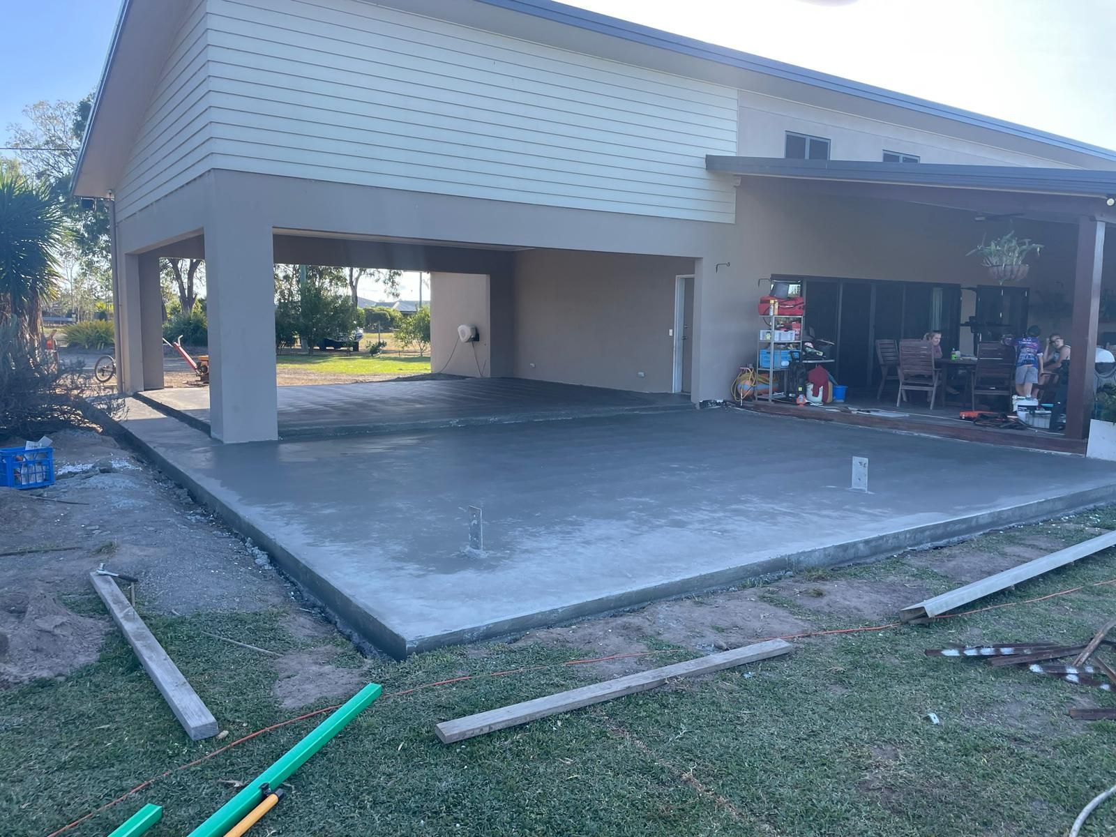 A Newly Poured Concrete Patio Next to a House With an Open Carport — Ericson Constructions in Mareeba, QLD