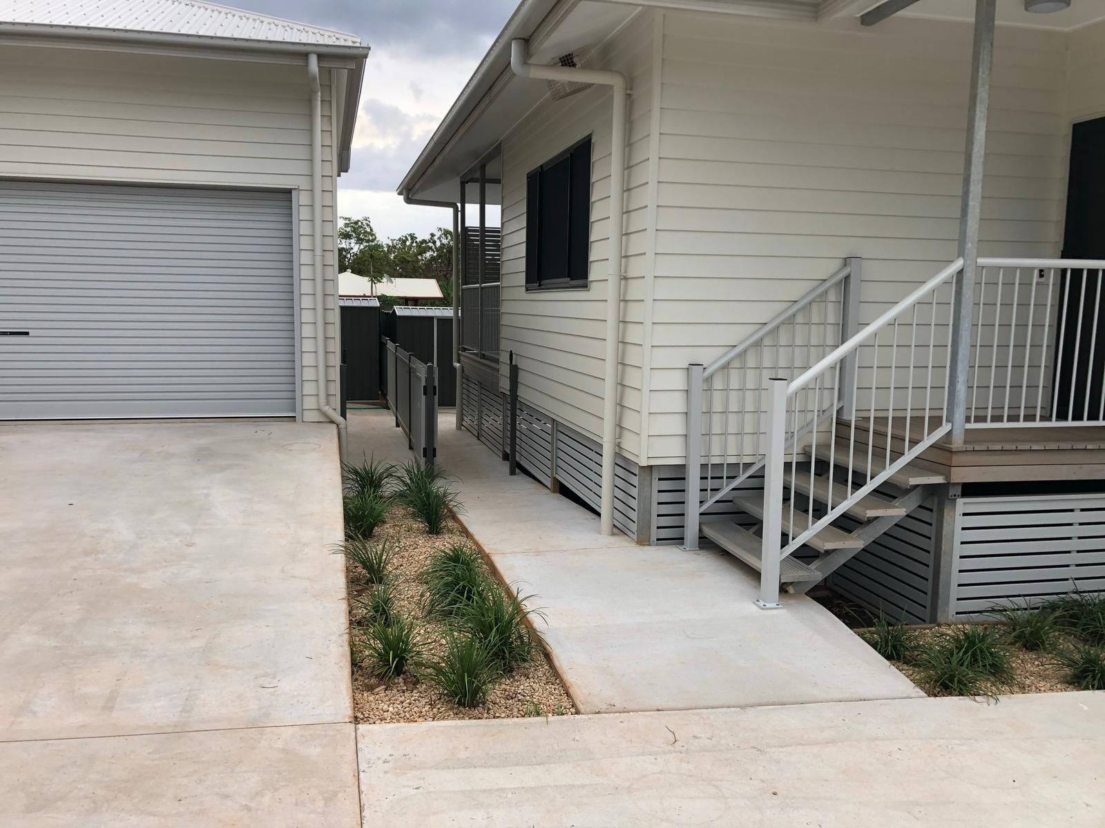 White House With Ramp and Stairs Leading to a Porch, and a Garage on the Left — Ericson Constructions in Mareeba, QLD