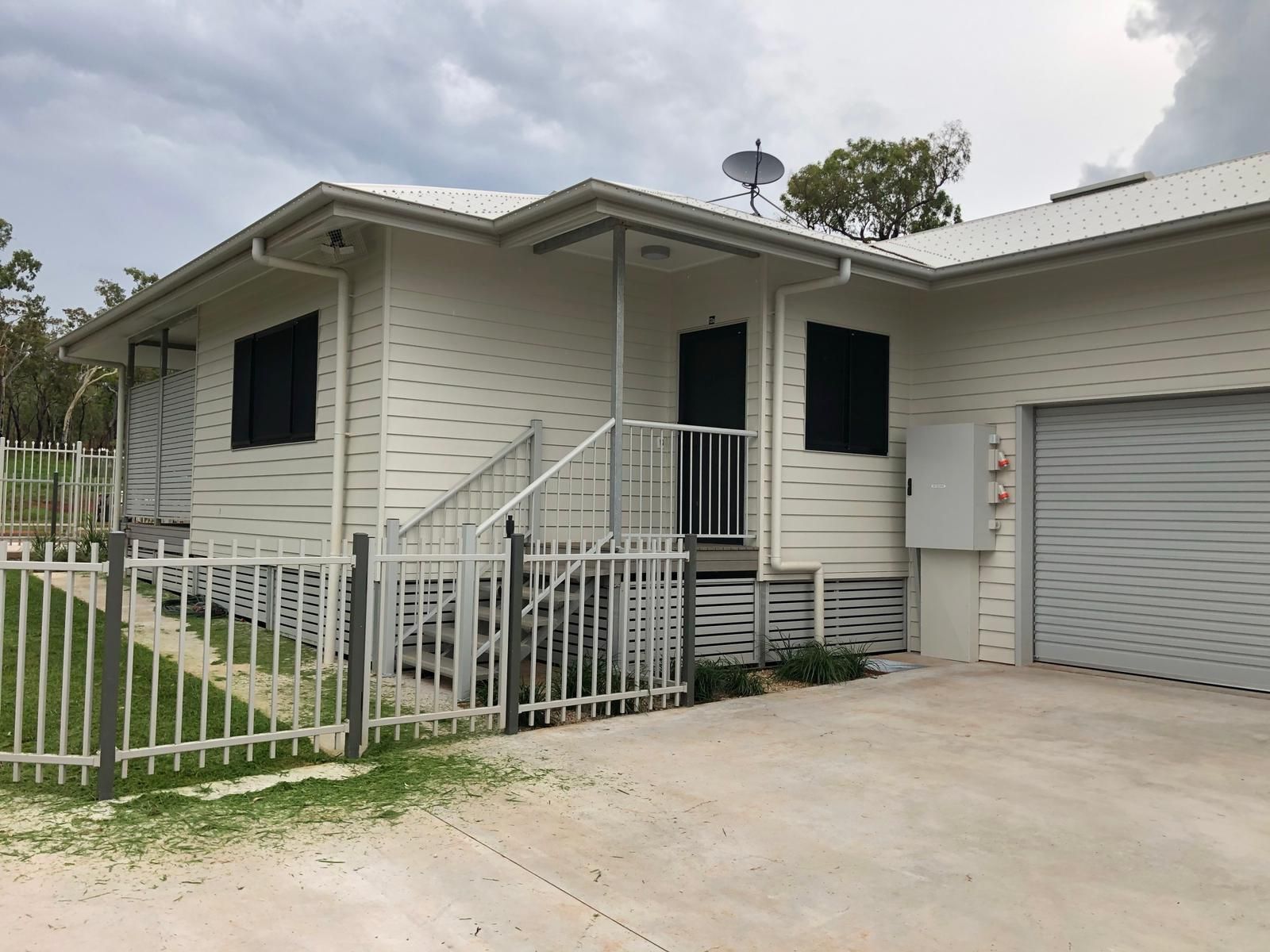 Building under construction with exposed wooden beams, beige walls, and a flat roof.