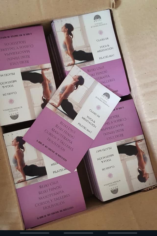 Caja de tarjetas con instrucciones de yoga. Cada una presenta a una mujer en una postura y texto en un idioma extranjero.