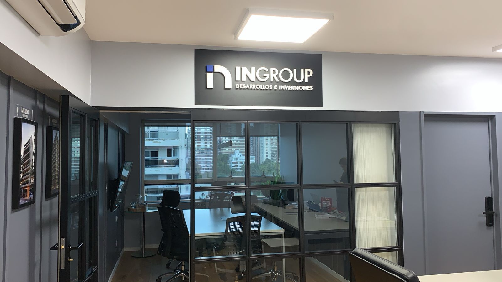 Interior de la oficina de INGROUP con cartel sobre una sala de conferencias con paredes de vidrio