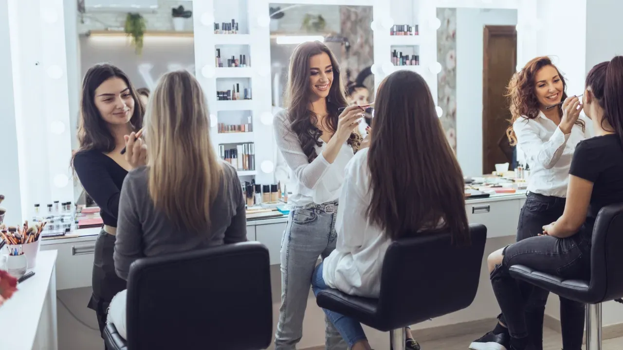 jeunes femmes en train de se faire maquiller dans un salon de beauté