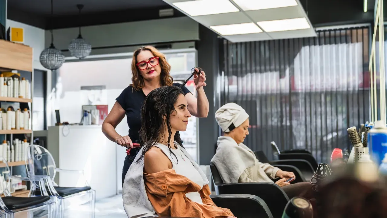 jeune femme en train de se faire coiffer dans un salon de coiffure