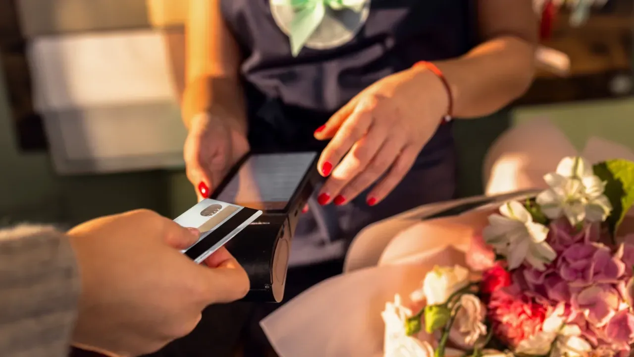 femme en train de donner sa carte bancaire dans un salon de coiffure