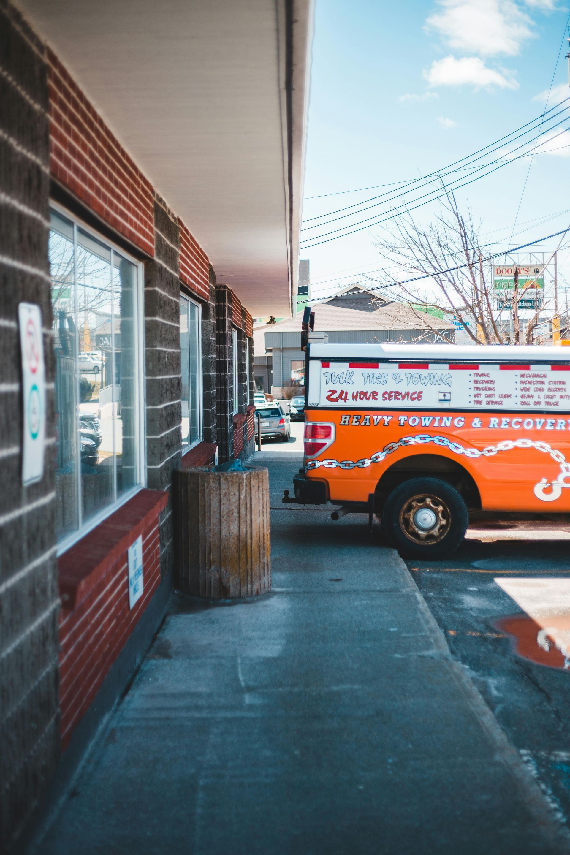 Exterior of a brick building with a bright orange truck parked beside it.
