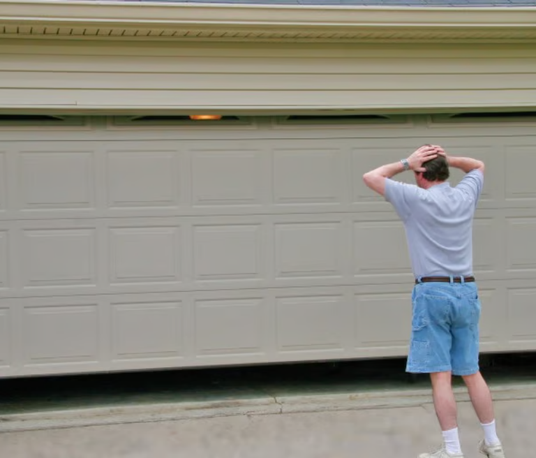 Man frustrated by partially open garage door.
