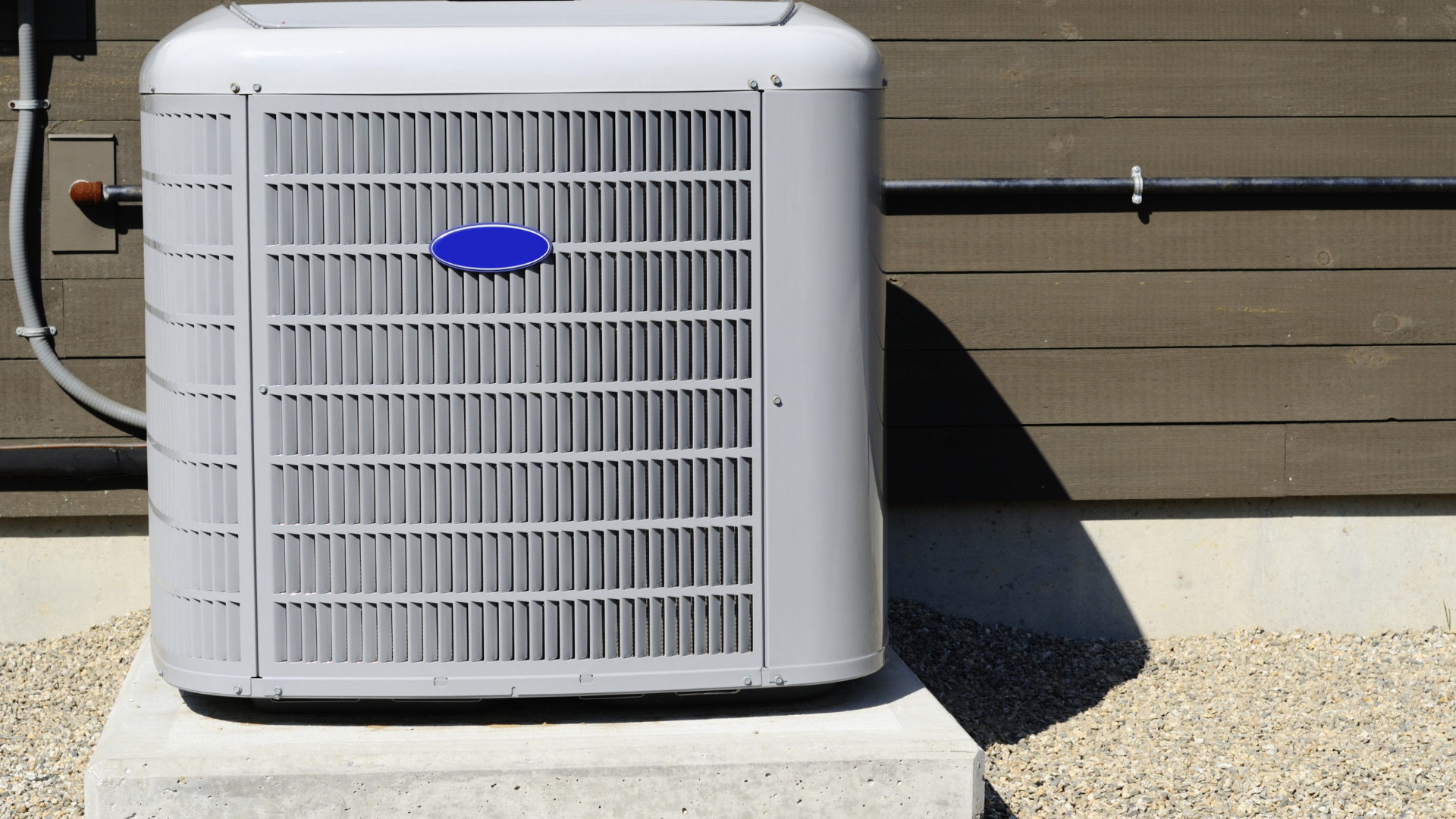 A carrier air conditioner is sitting on a concrete block