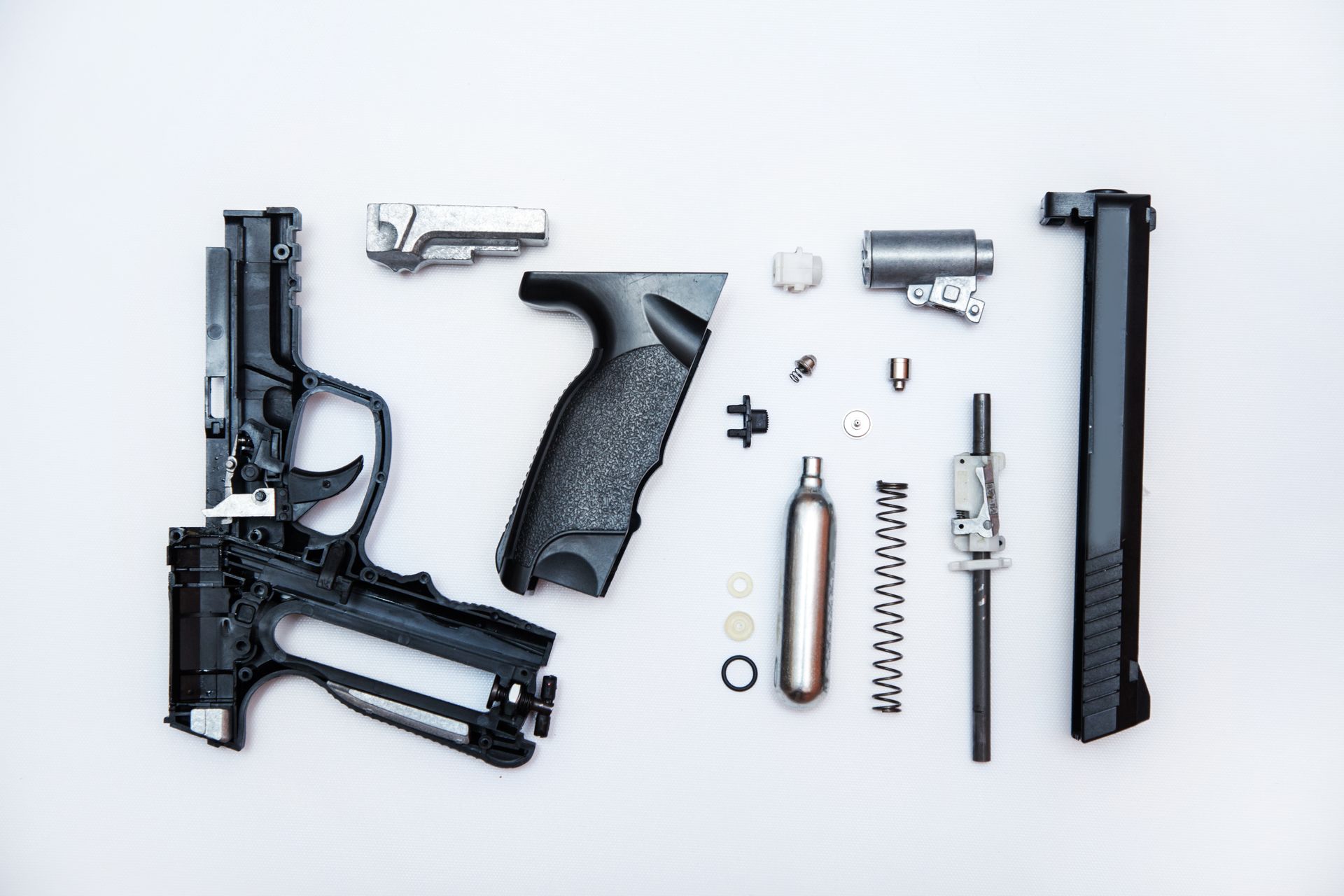Disassembled gun parts on a white background.