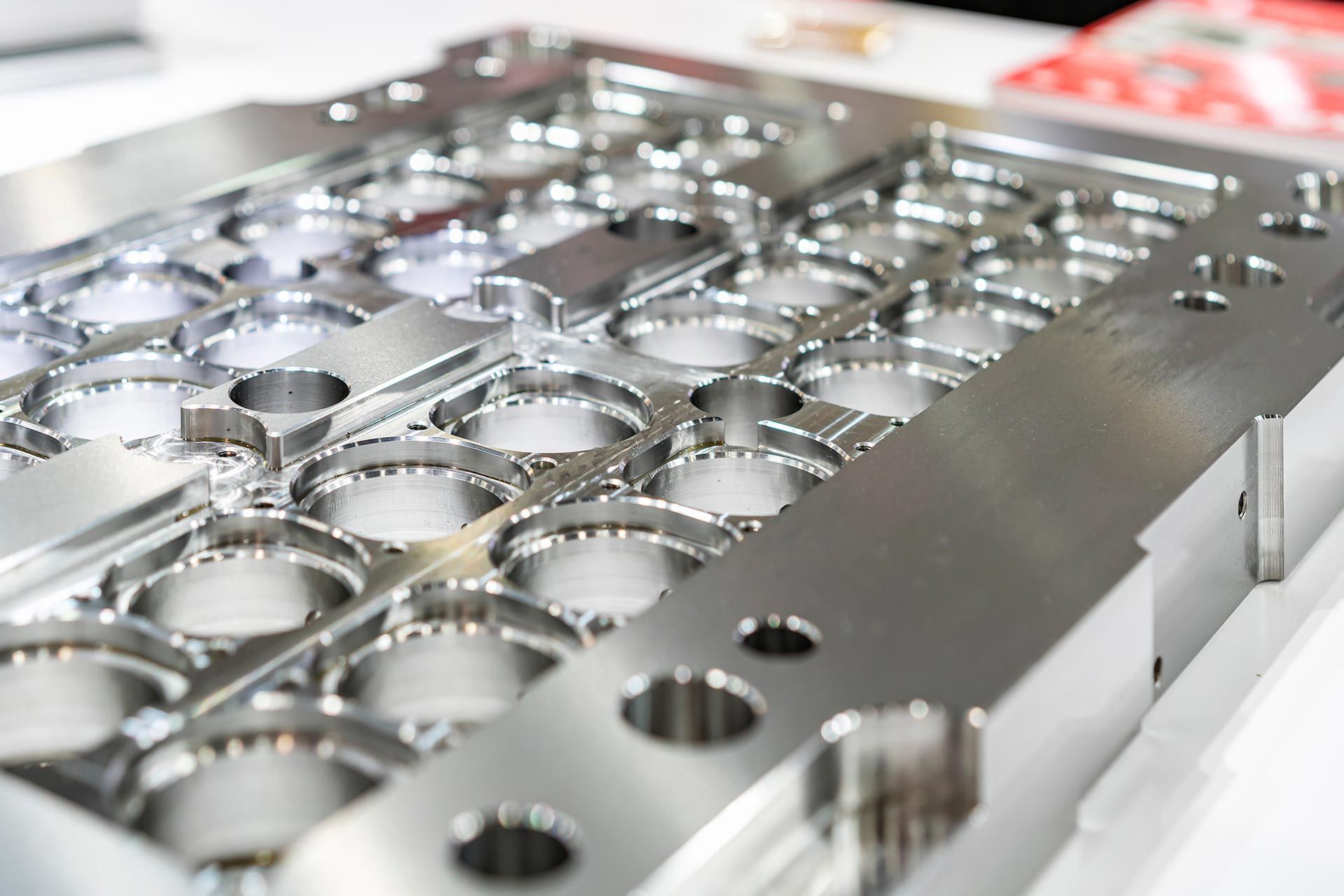Precision machined metal mold plate with circular cutouts and polished industrial detailing. Precision machined metal mold plate with circular cutouts and polished industrial detailing.