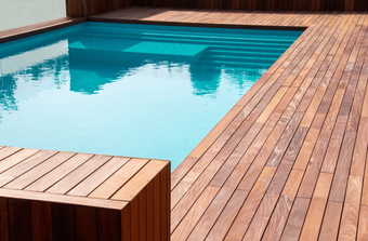 A swimming pool with a wooden deck surrounding it