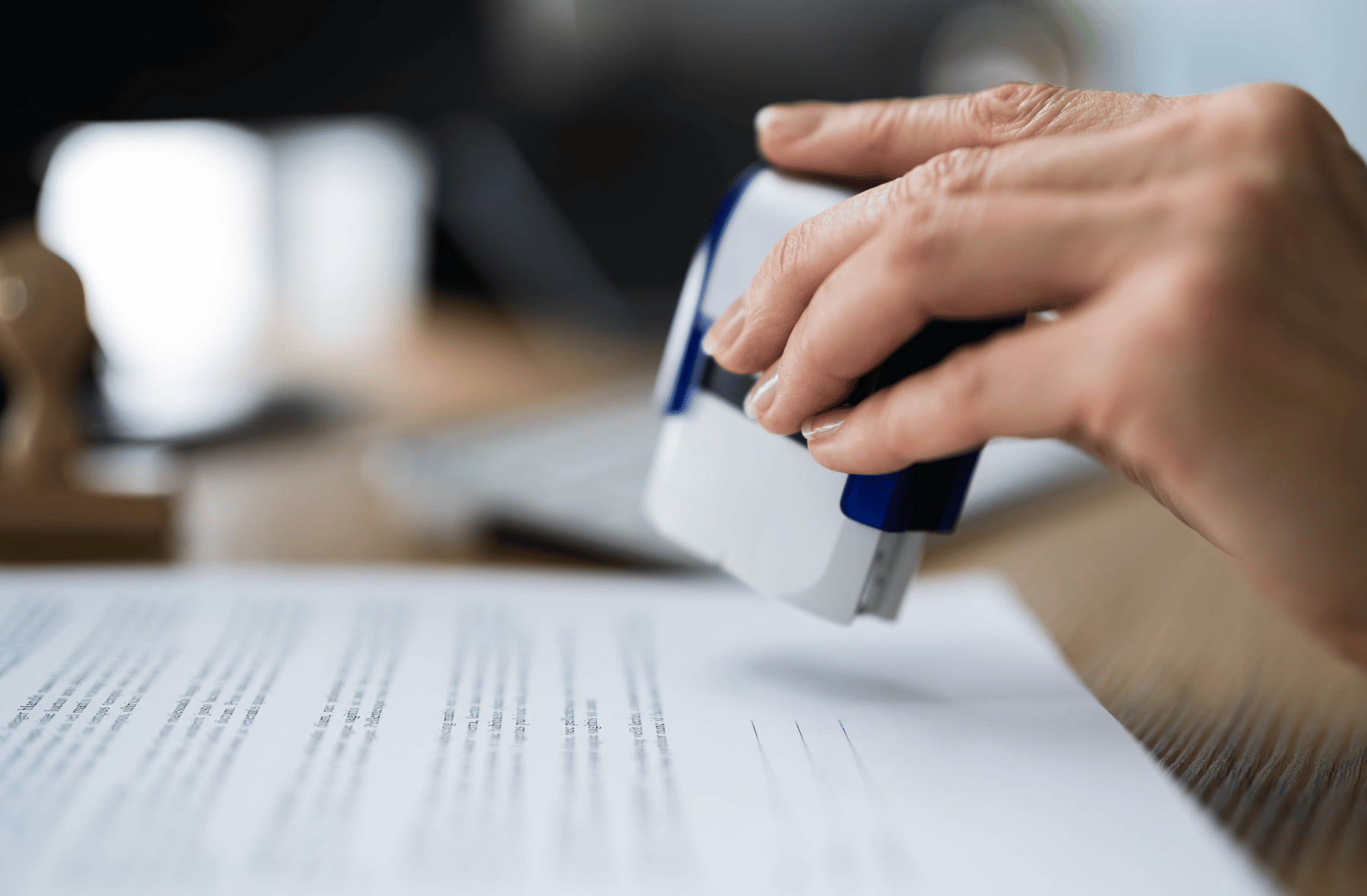 A person is stamping a piece of paper with a stamp.