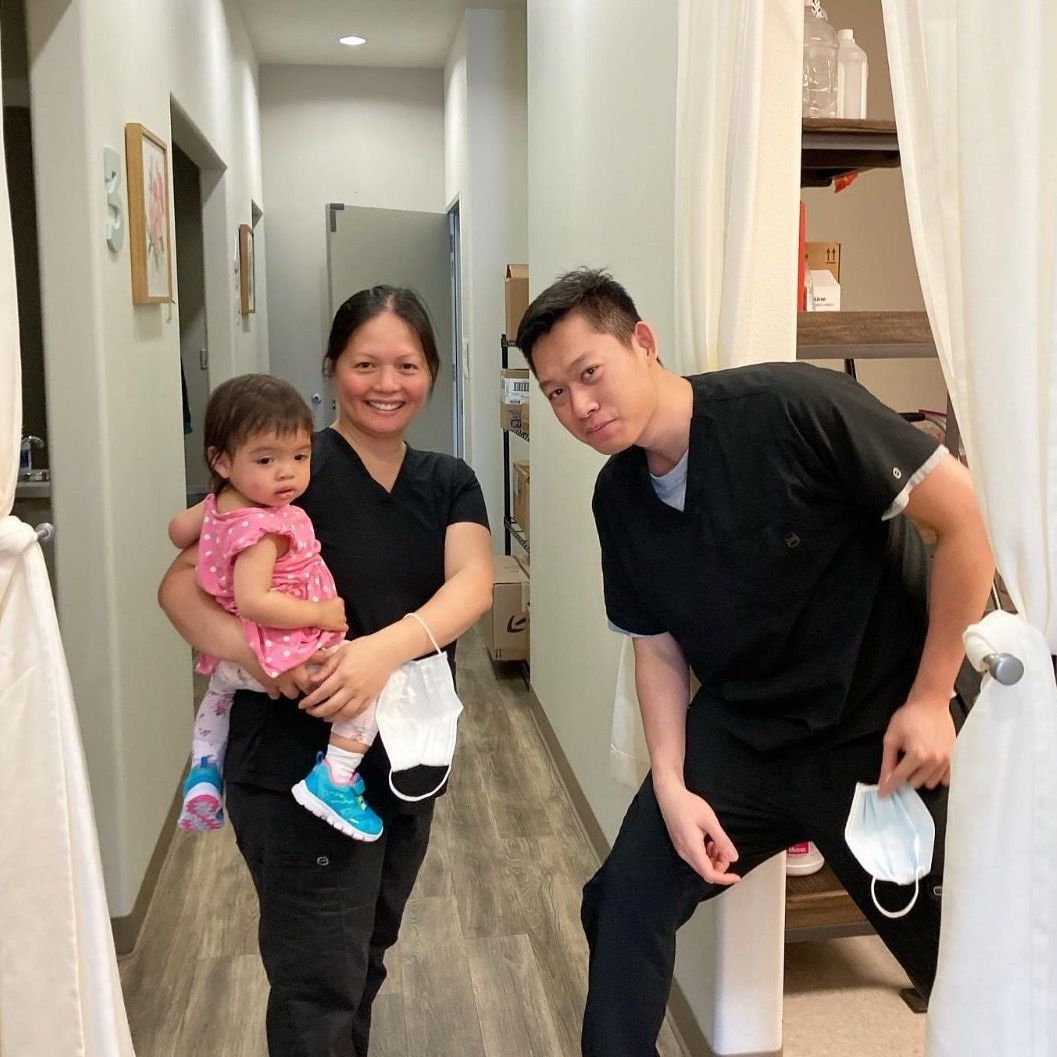 A man and a woman holding a baby in a hallway