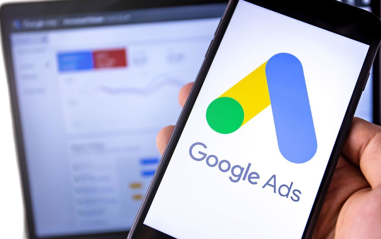 a person is holding a cell phone with the google ads logo on it .