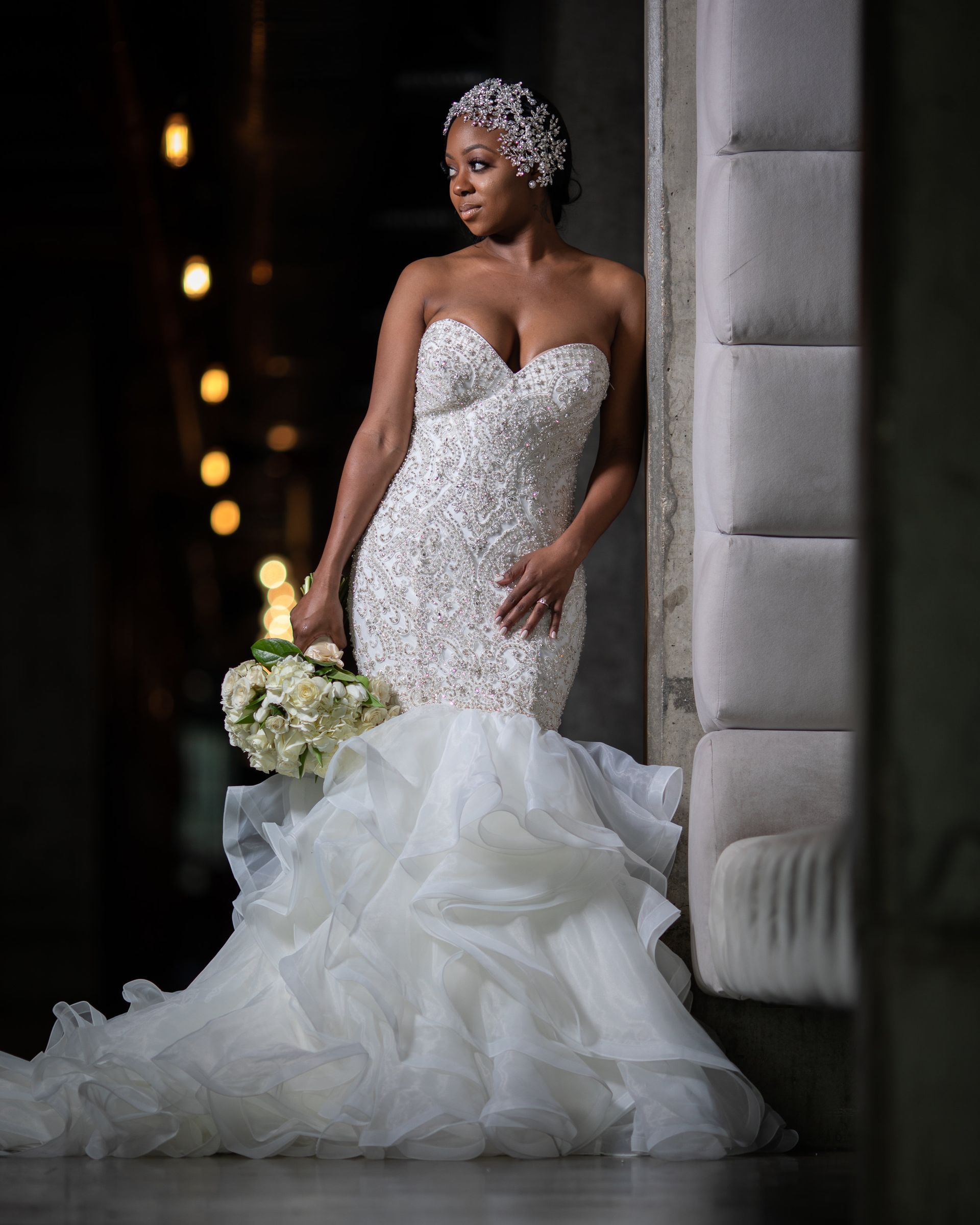 A woman in a wedding dress is holding a bouquet of flowers.