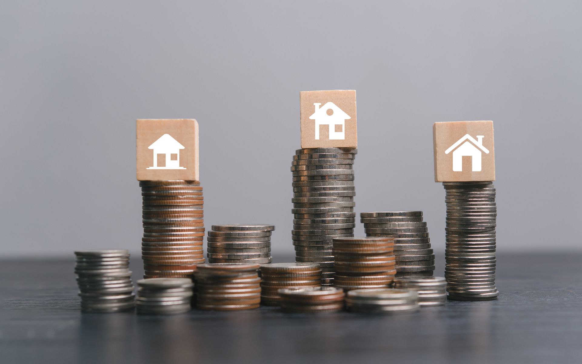 A stack of coins with wooden blocks with houses on them.