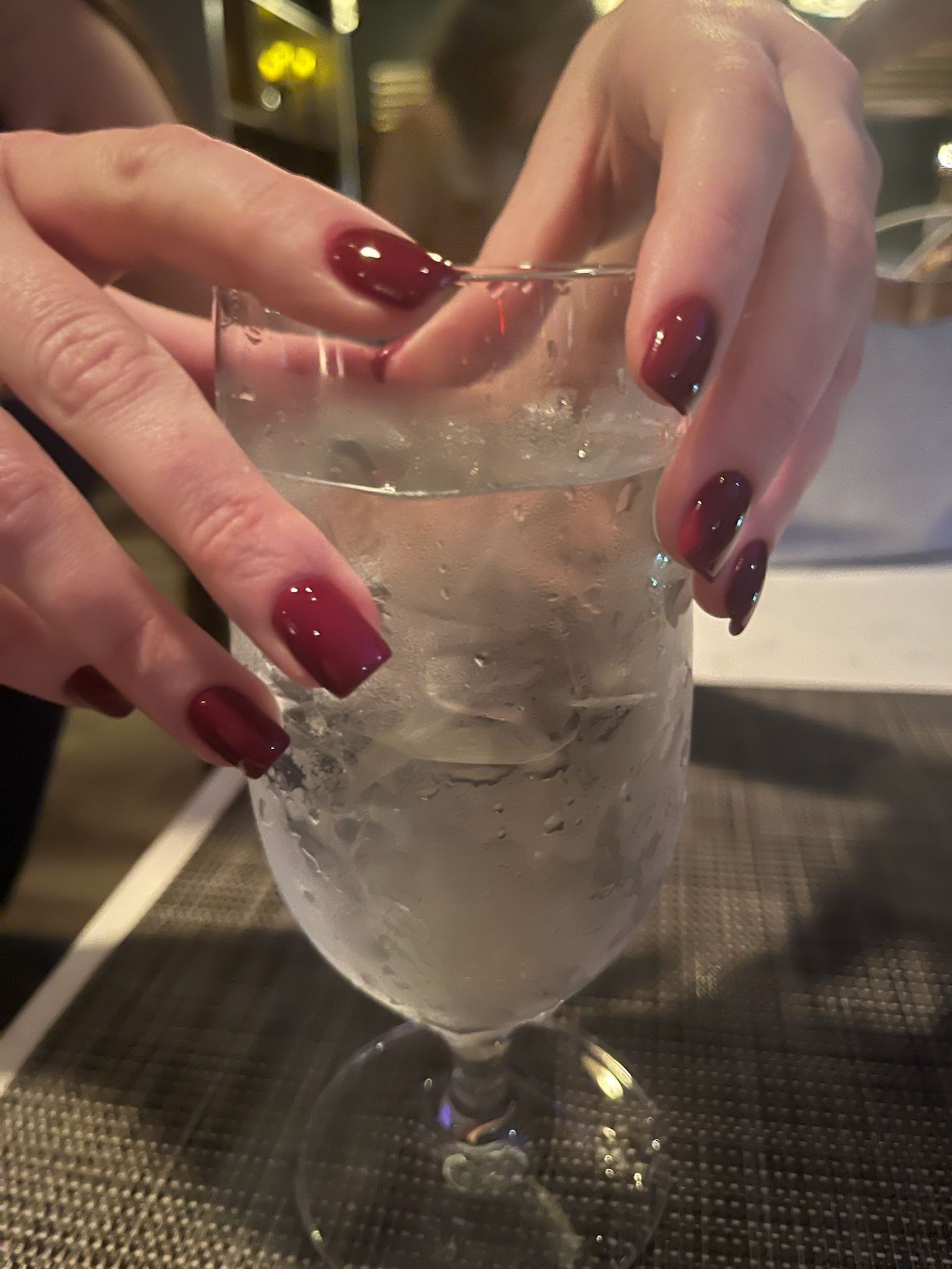 A close up of a woman 's hands with white nails.