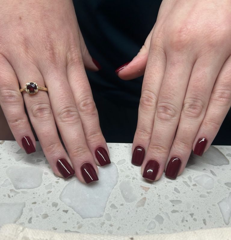 A close up of a woman 's hands with pink nails.