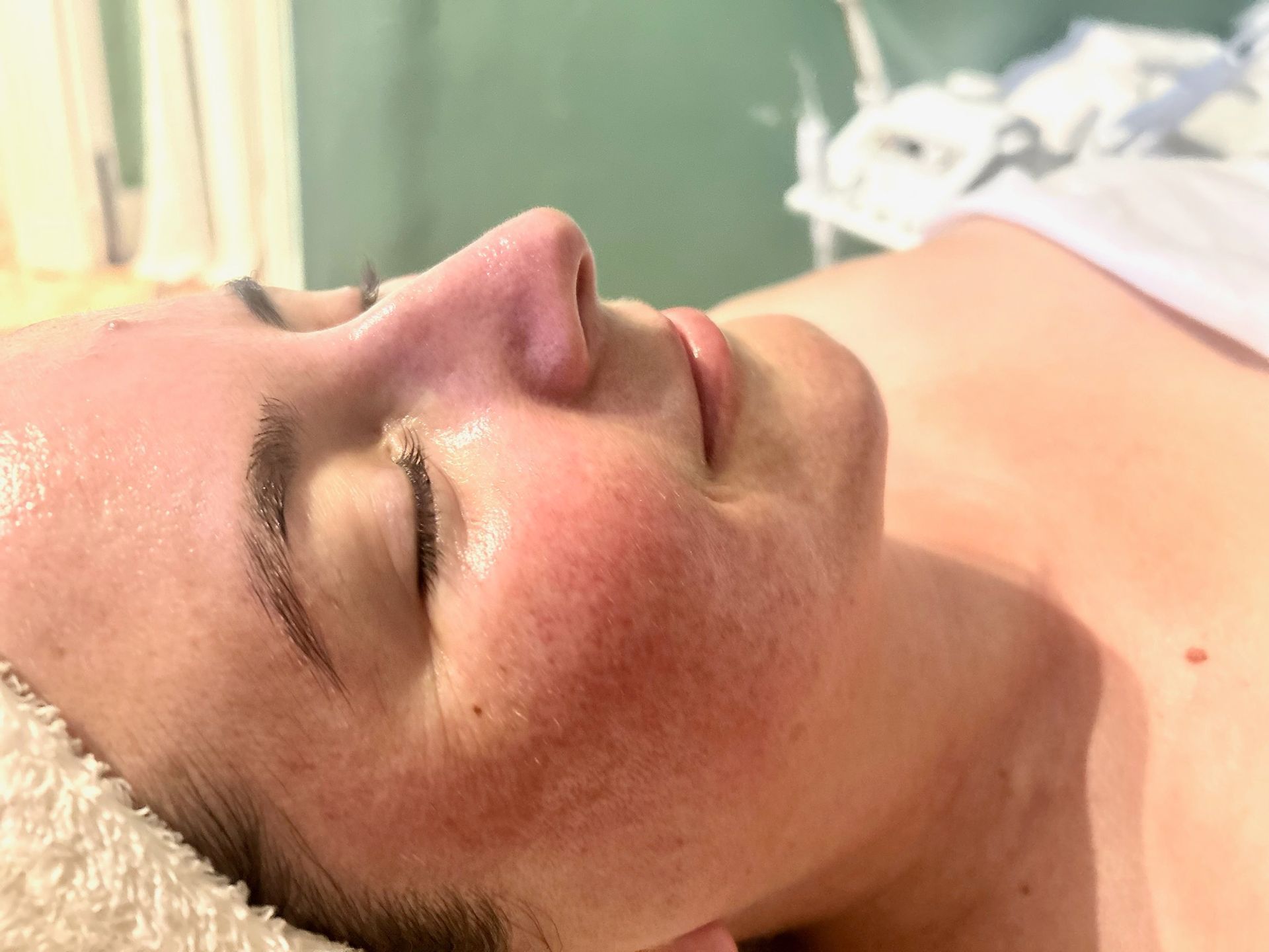 A woman is getting a facial treatment at a beauty salon.