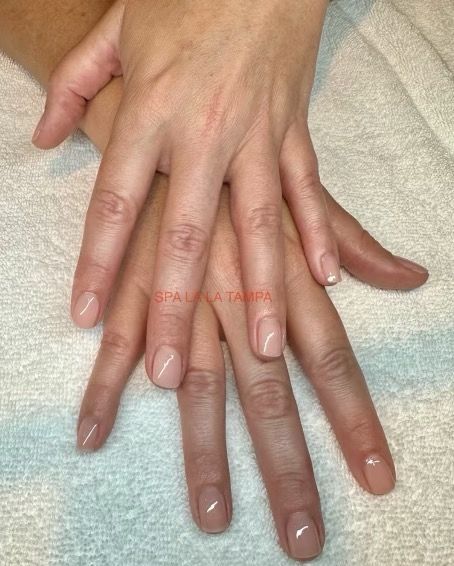 A woman is getting her nails painted at a nail salon.