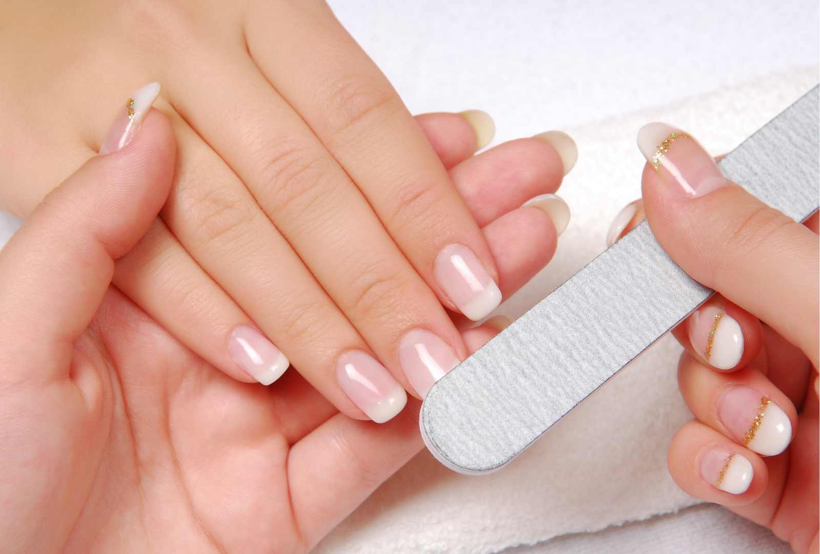 A woman is getting her nails done at a nail salon.
