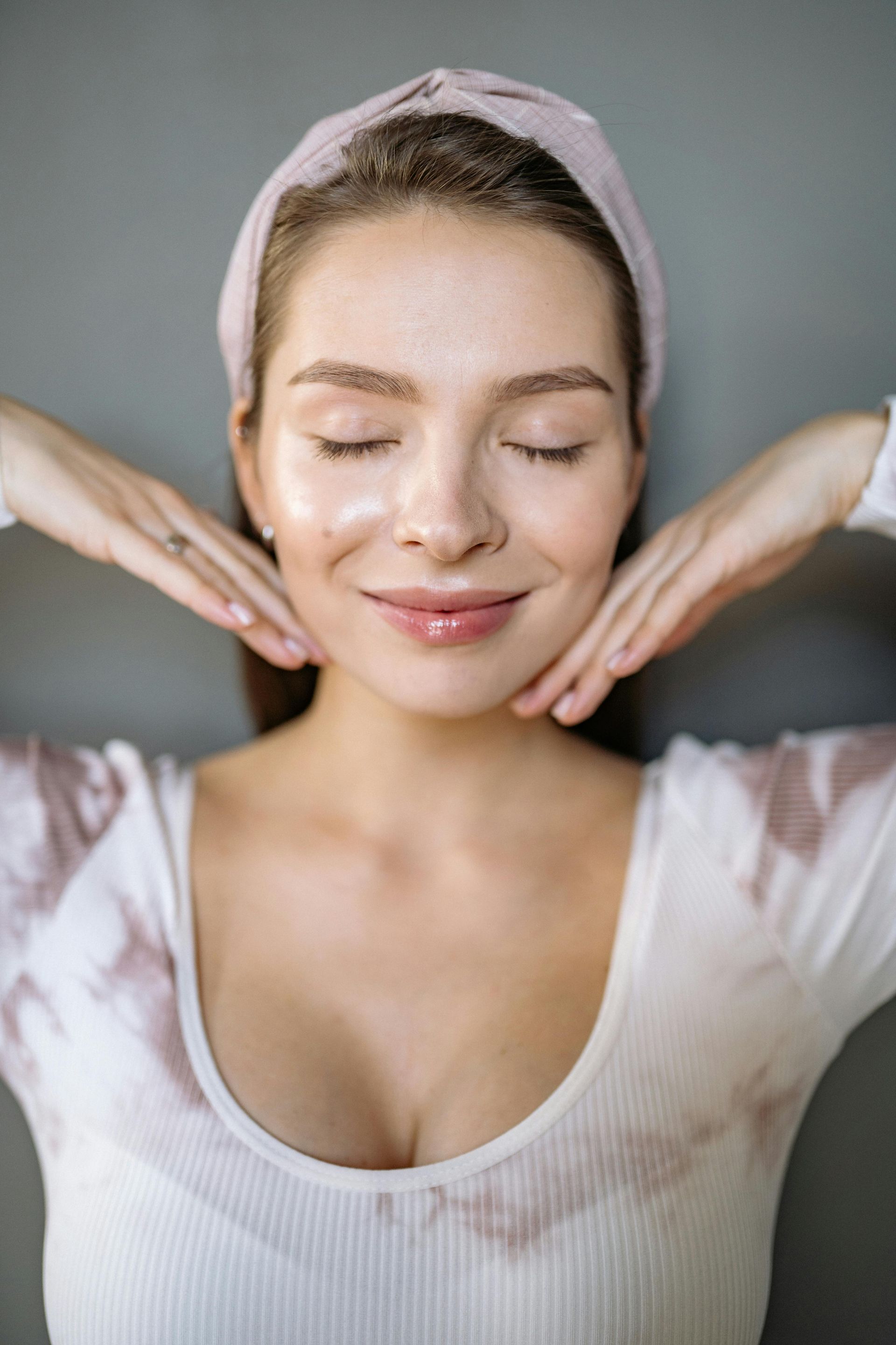 Woman in a blissful state with glowing skin and eyes closed after recieving a anti-facial at Spa La La Tampa.
