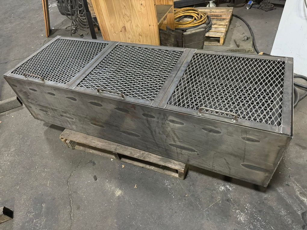 A stainless steel grill is sitting on top of a wooden pallet.