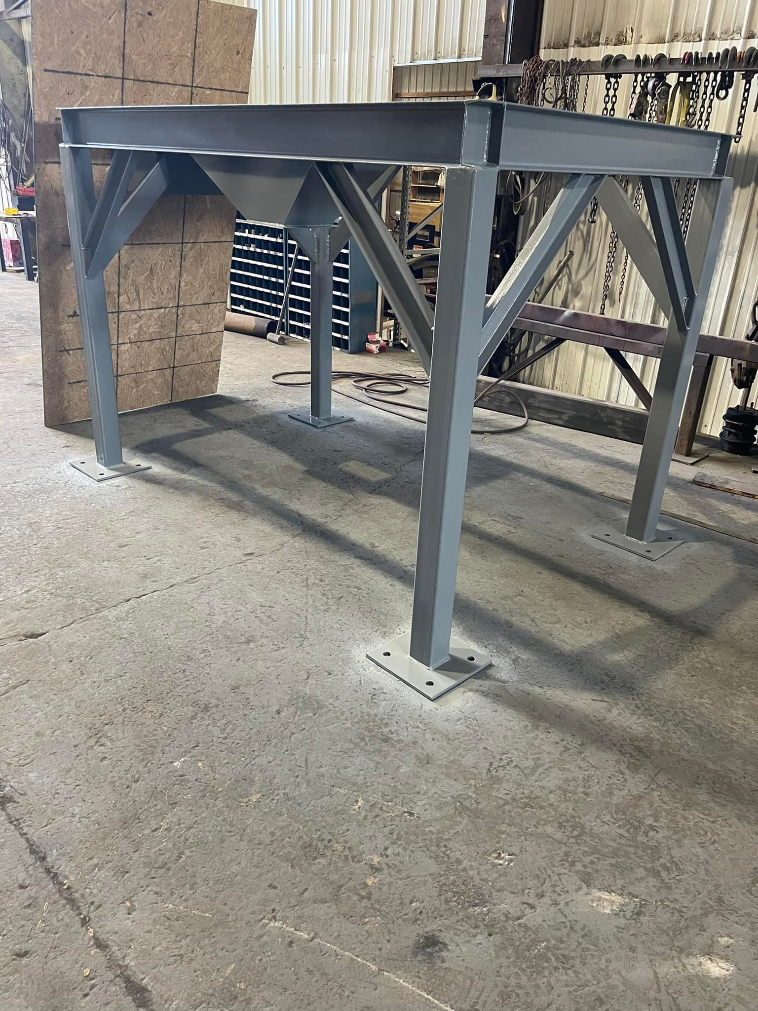 A metal structure is sitting on top of a concrete floor in a warehouse.