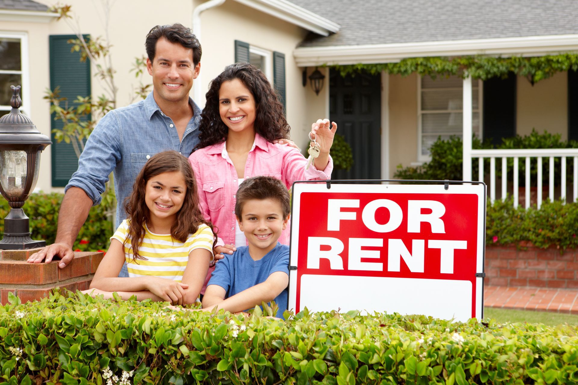 family with keys next to a For Rent sign - linked to homes for rent