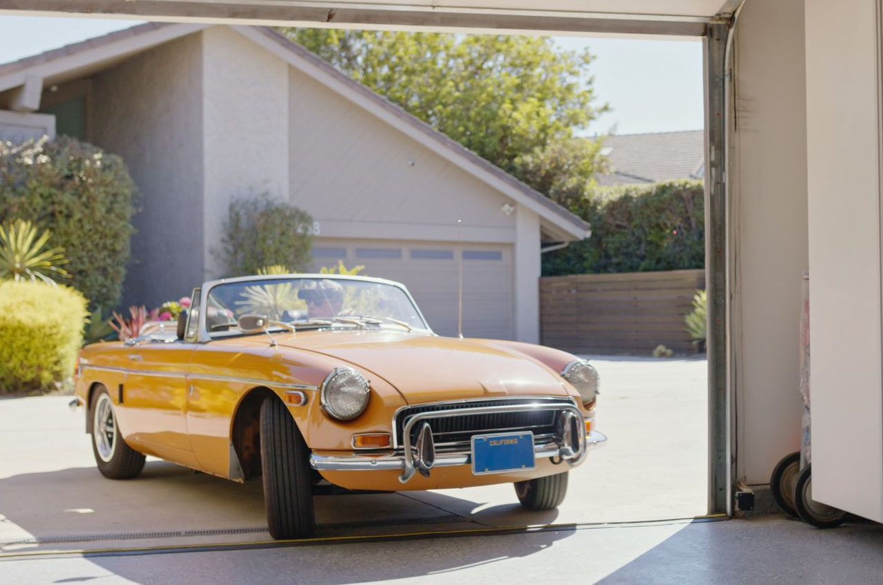 Beagle dog running on grass with an orange ball in its mouth.