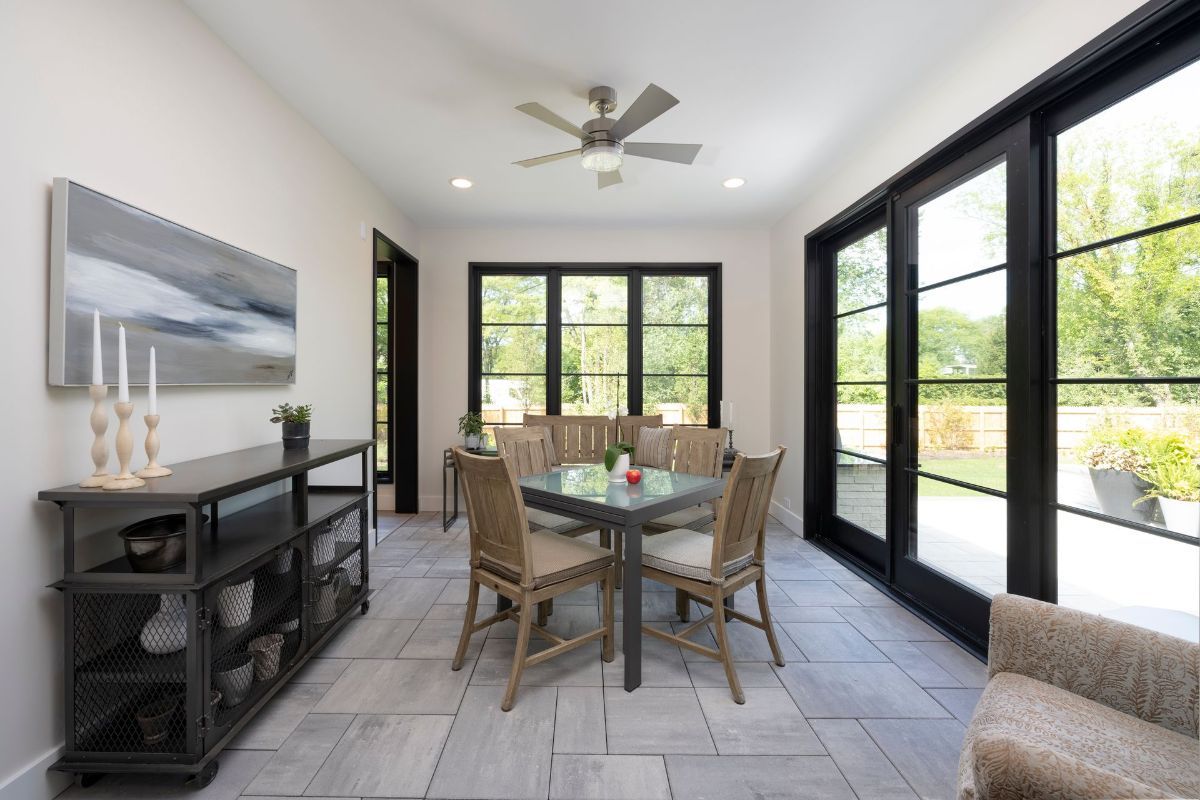 A dining room with a table and chairs and a ceiling fan.