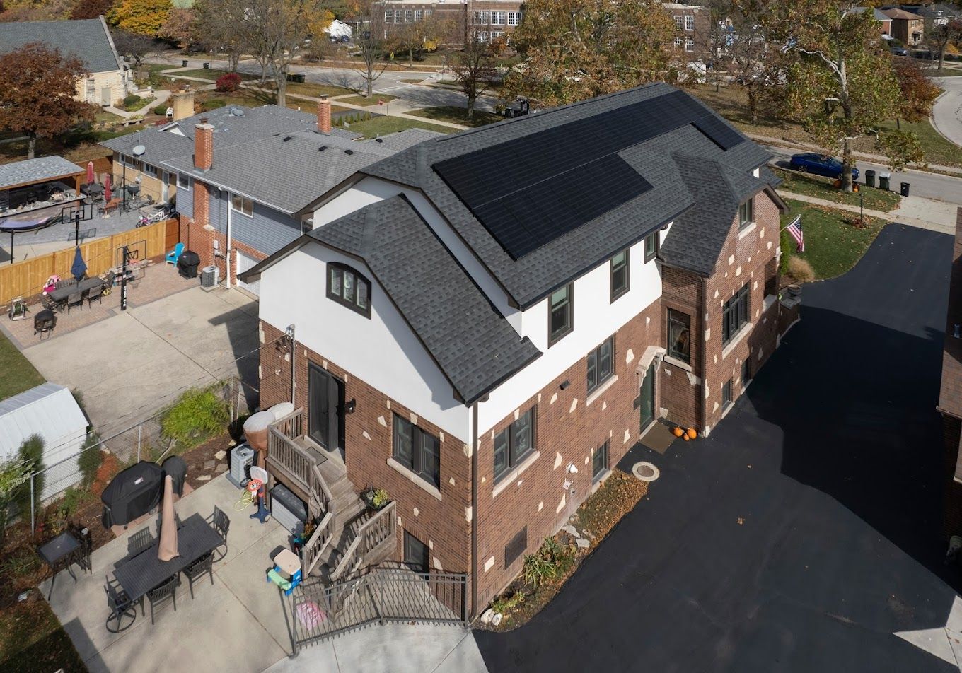 An aerial view of a house with solar panels on the roof