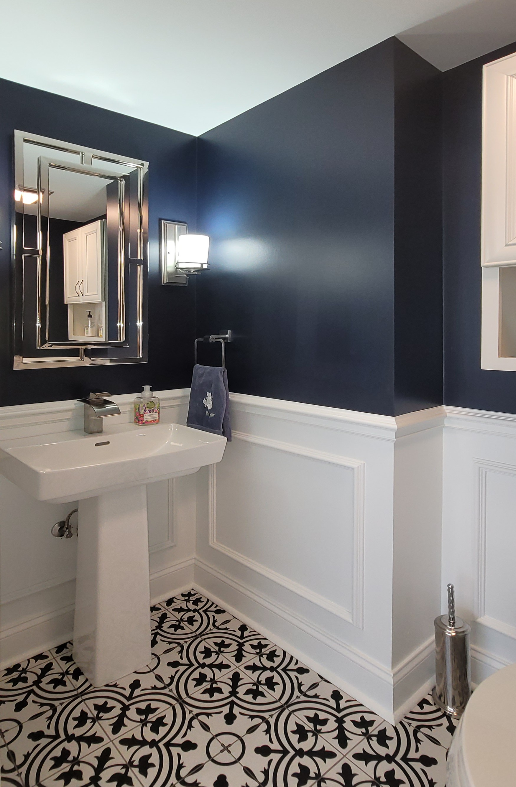 A bathroom with a sink , mirror , and tile floor.