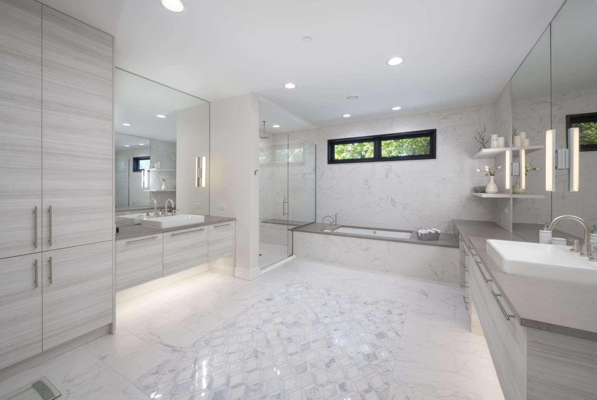 A bathroom with two sinks , a tub and a shower.