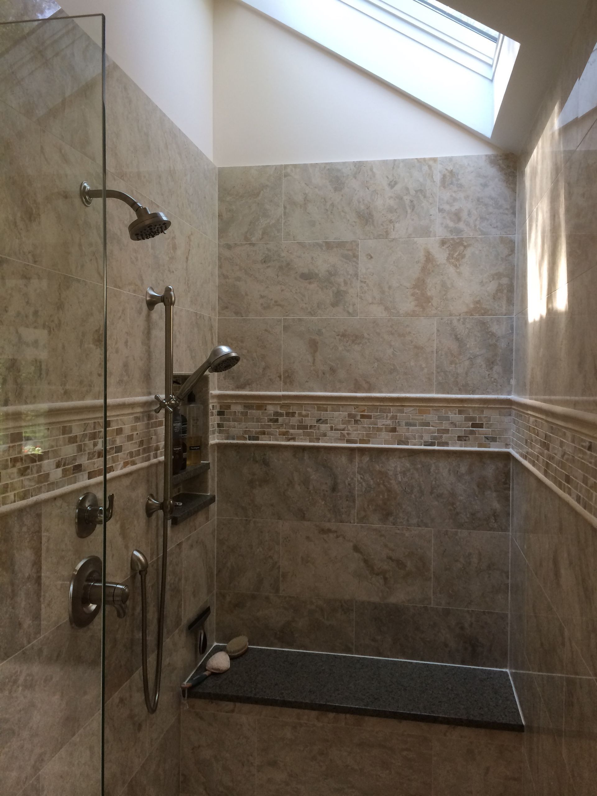 A bathroom with a walk in shower and a skylight