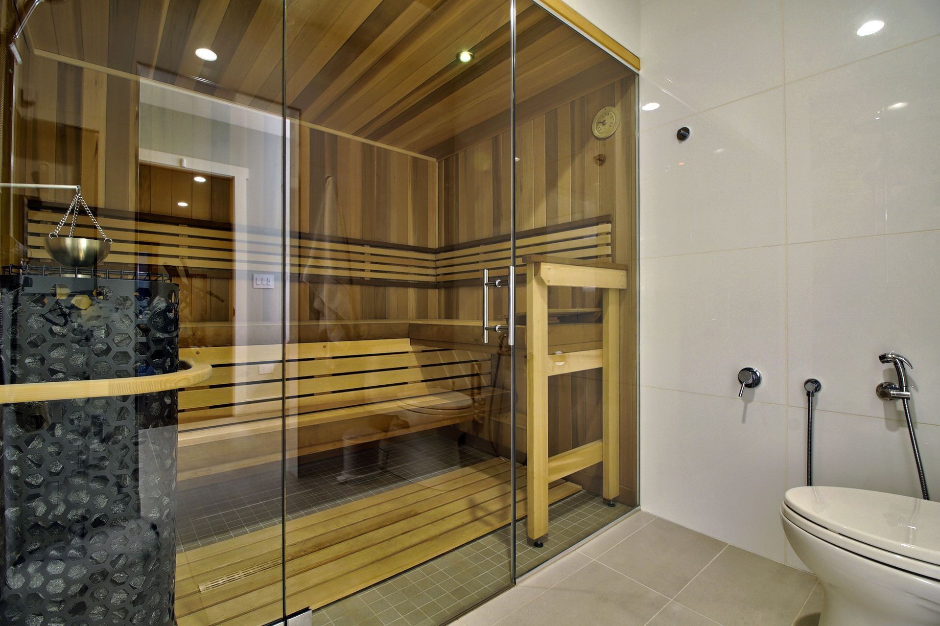 A bathroom with a wooden sauna and a toilet.