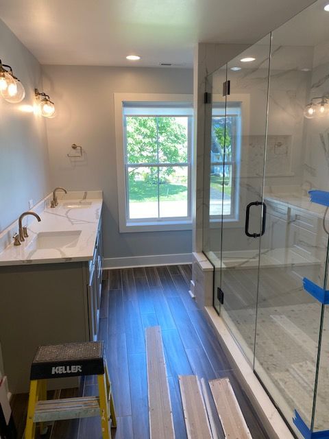 A bathroom with two sinks and a walk in shower
