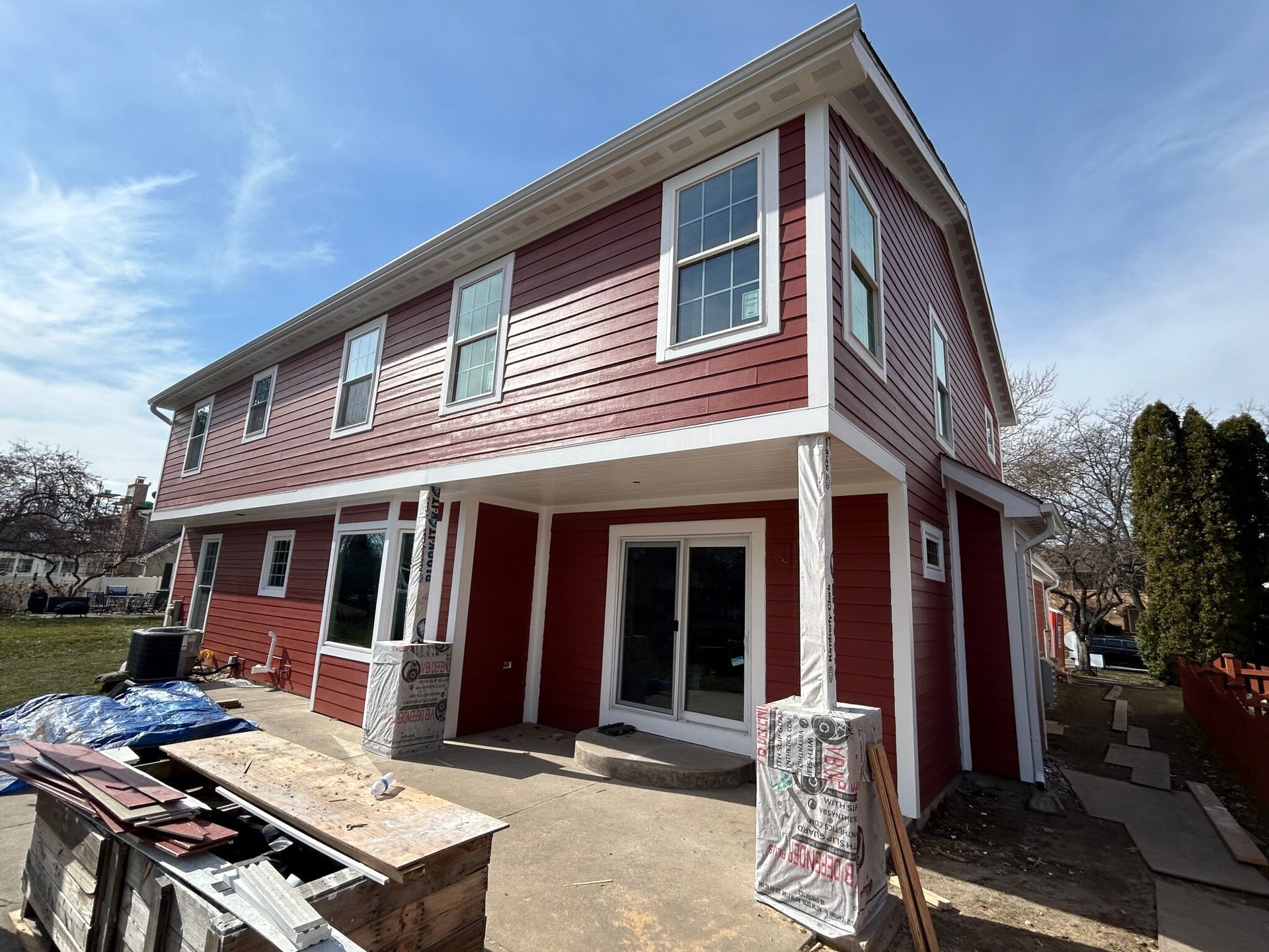 A red house with white trim is under construction