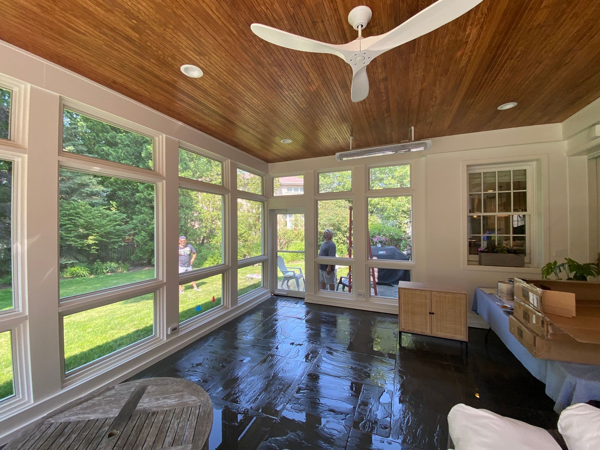 A room with a lot of windows and a ceiling fan