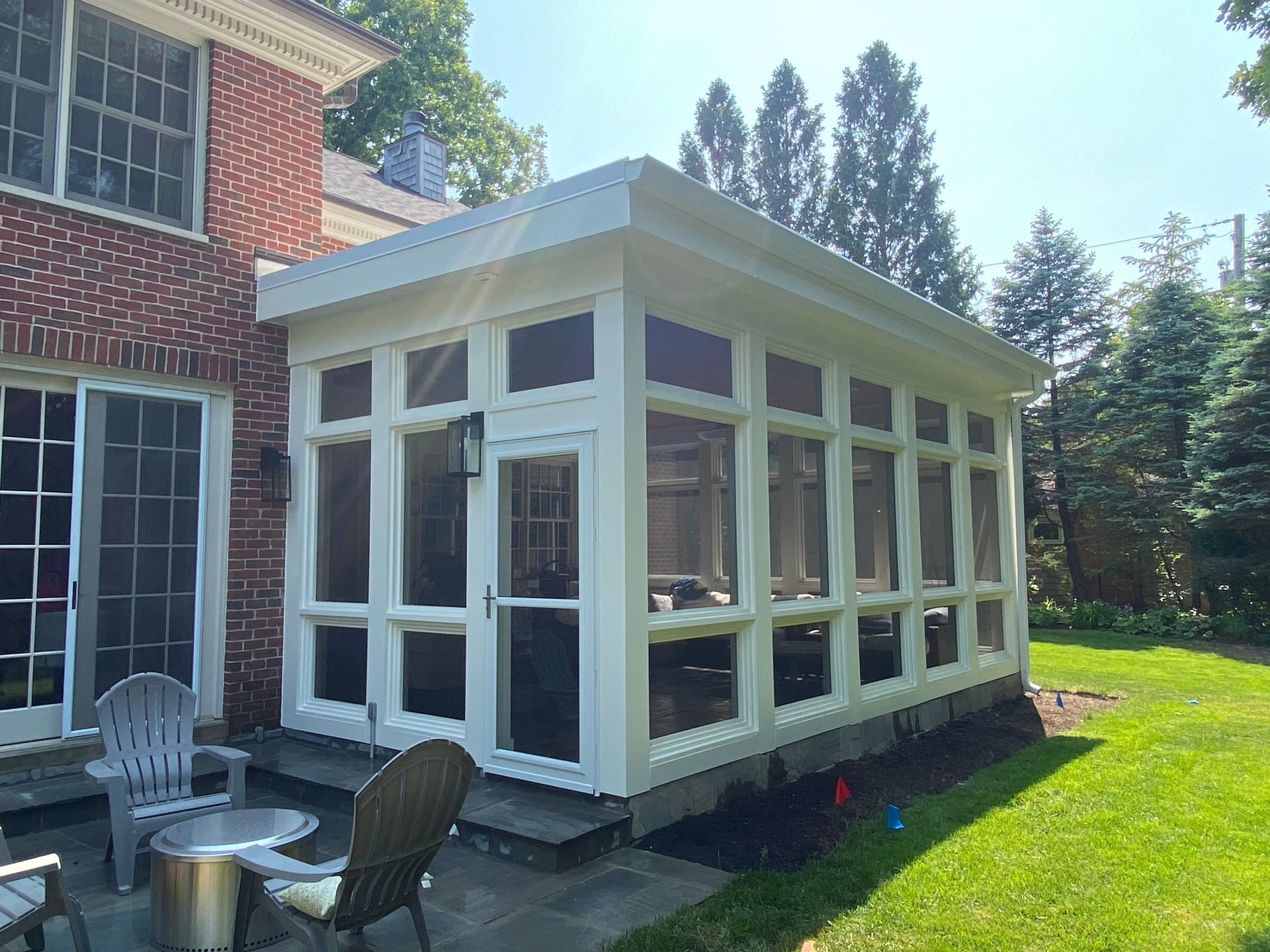There is a screened in porch in the backyard of a house.